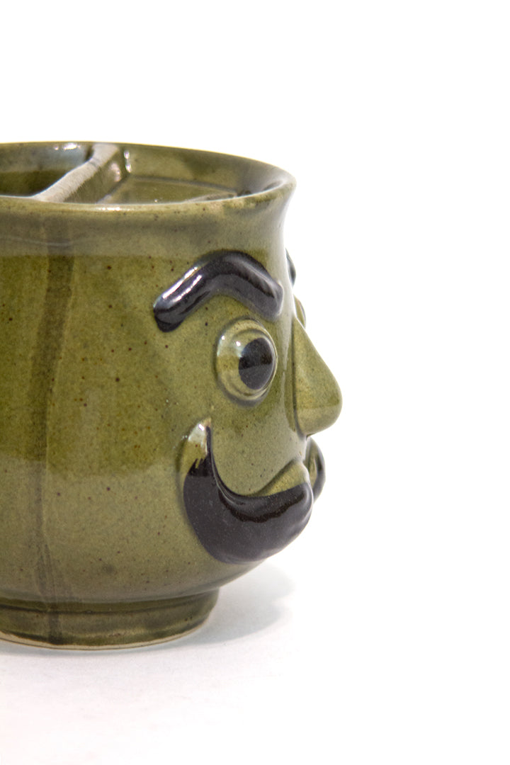 Groene vintage snorrenmok met gezicht