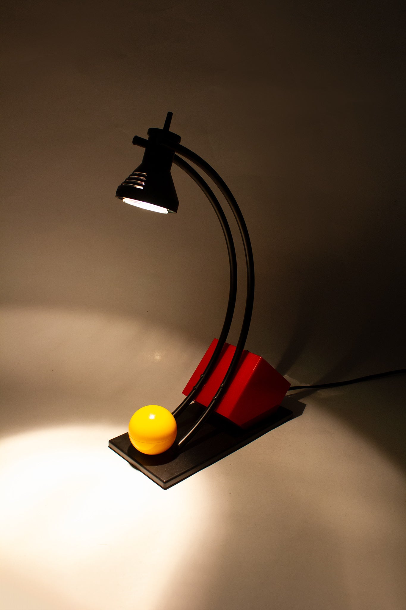 Zwarte 90s memphis-style bureaulamp met gele bal en rode kubus