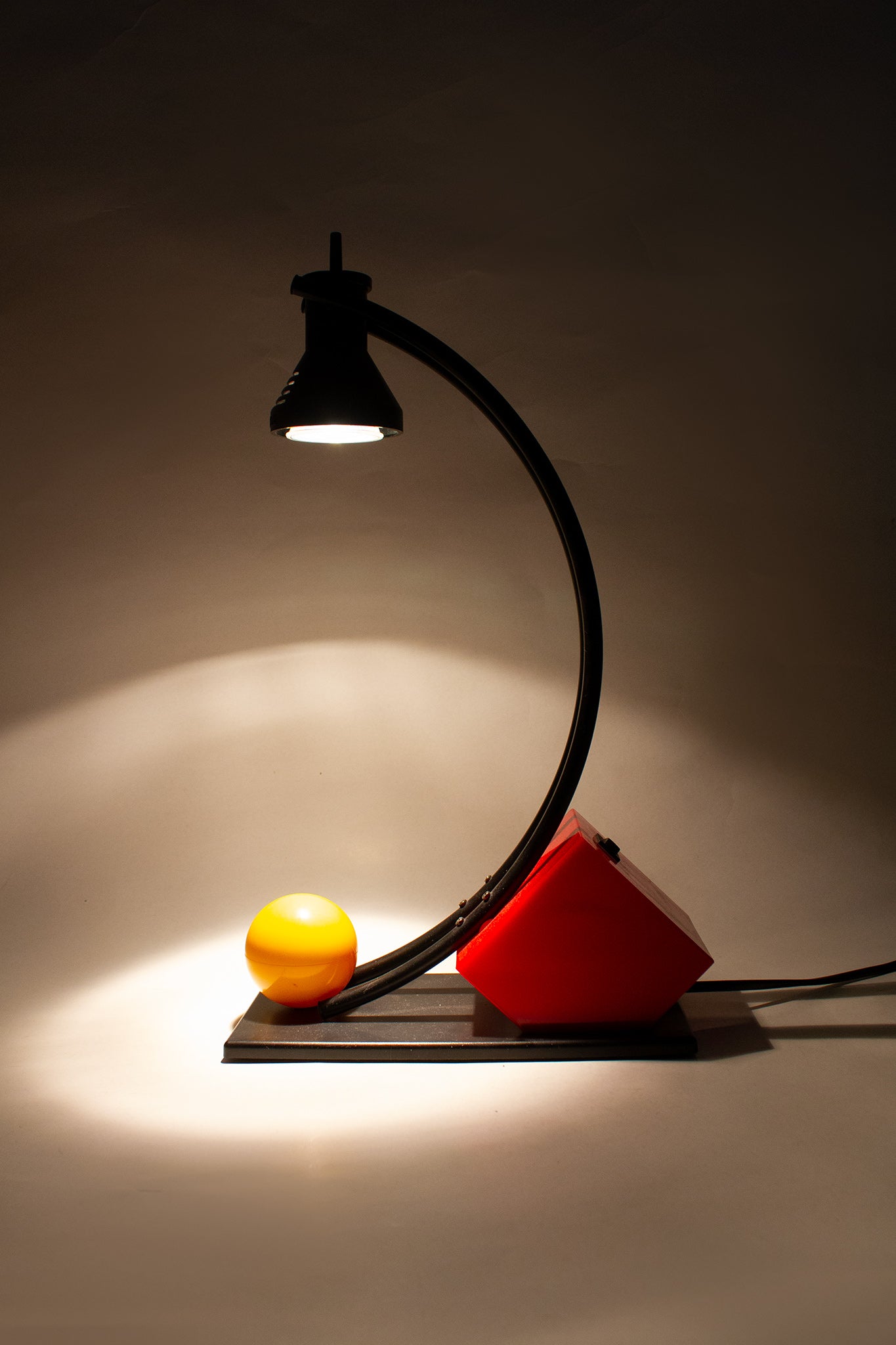 Zwarte 90s memphis-style bureaulamp met gele bal en rode kubus
