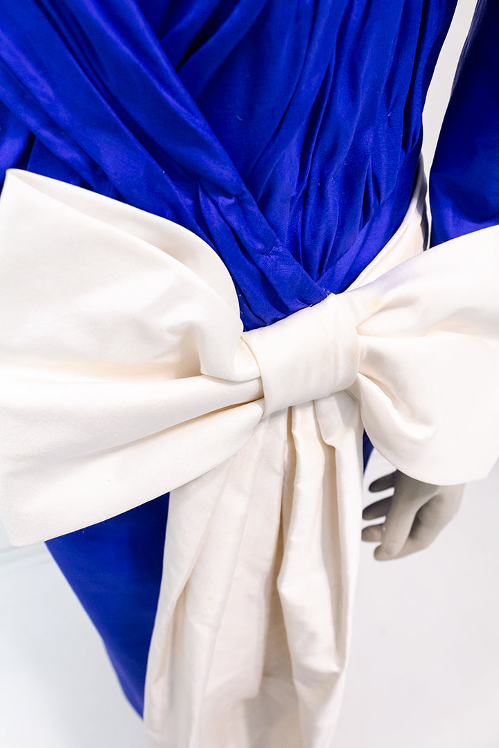 Blauwe jurk van zijde met grote crèmekleurige strik Fong Leng jaren 80
