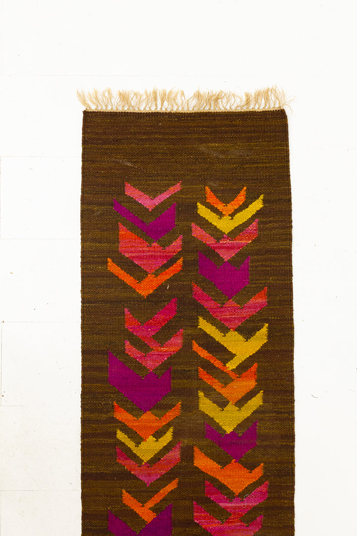 Bruine vintage loper met patroon van roze en gele pijlen