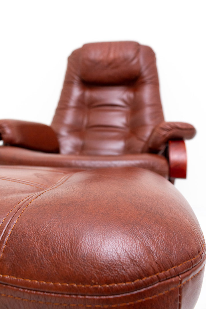 Draaifauteuil van bruin imitatieleer met verstelbare zitting en bijpassende voetenbankje