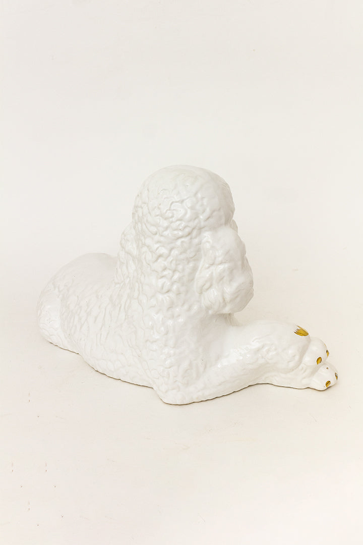 Groot beeld van een liggende witte poedel met vergulde details