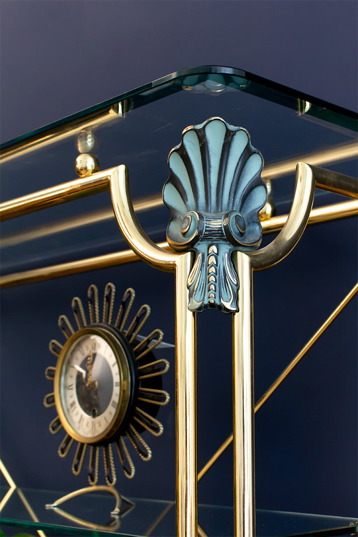 Hollywood Regency messing wandkast met marmeren onderplaat, glazen schappen en schelpdecoraties