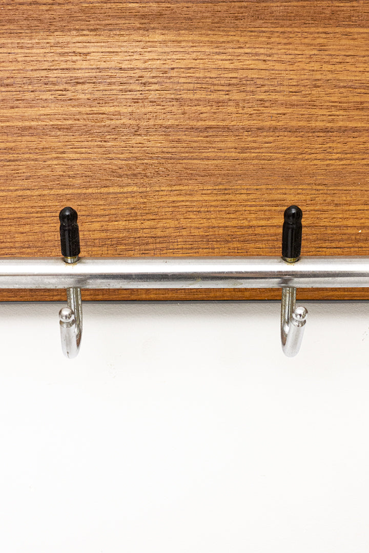 Jaren 60 wandkapstok met zwarte bies en basis van teak-fineer