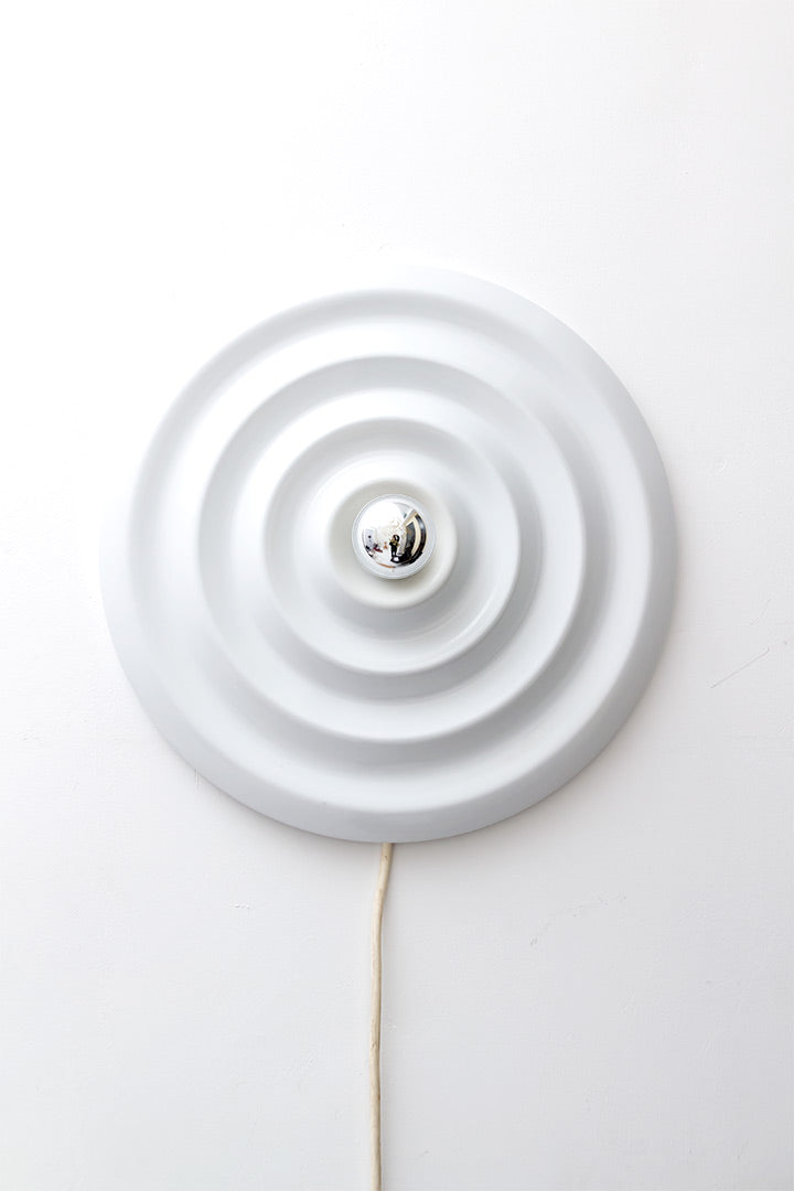 Deze mooie vintage ronde wandlamp draagt de naam Andro Wave en is ontworpen voor Sompex door Neufeld & Sein. De lamp is gemaakt van wit gelakt metaal