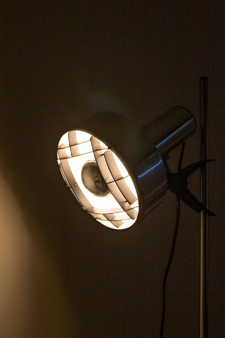 Verchroomde staande lamp met zwart raster in de spot 