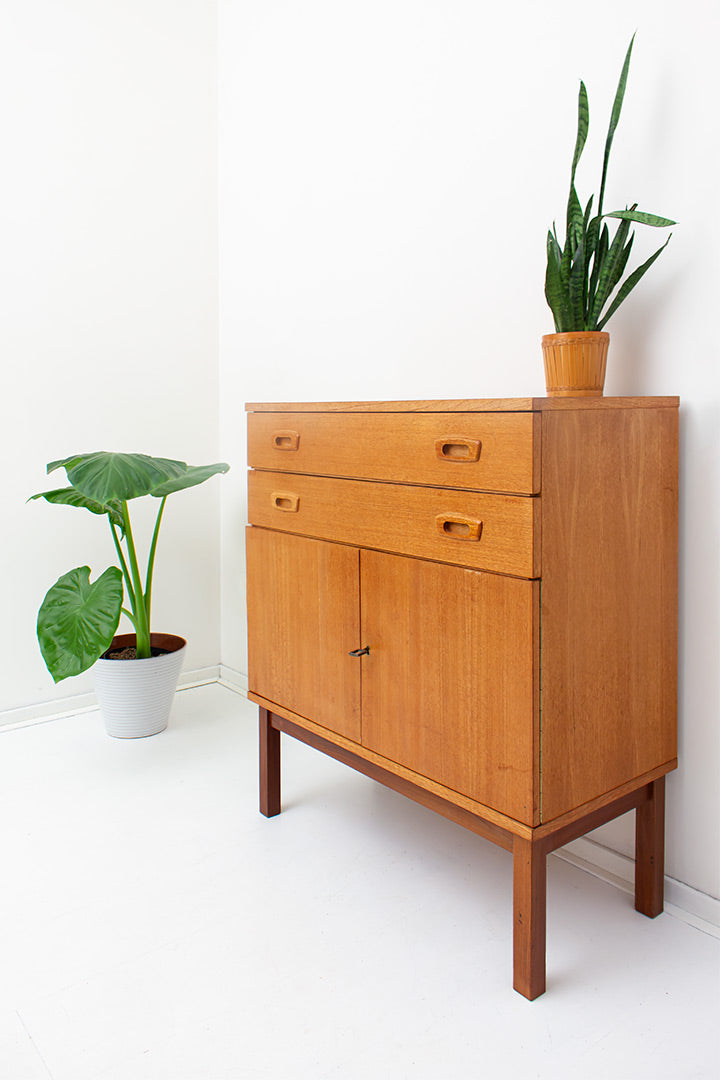 Vintage houten kast op hoge pootjes met handgrepen in Fristho stijl