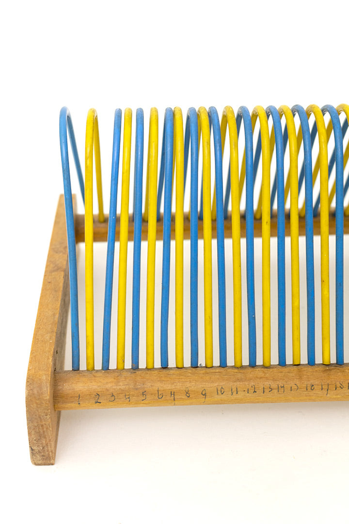 Vintage houten rek voor platen met gele en blauwe staanders