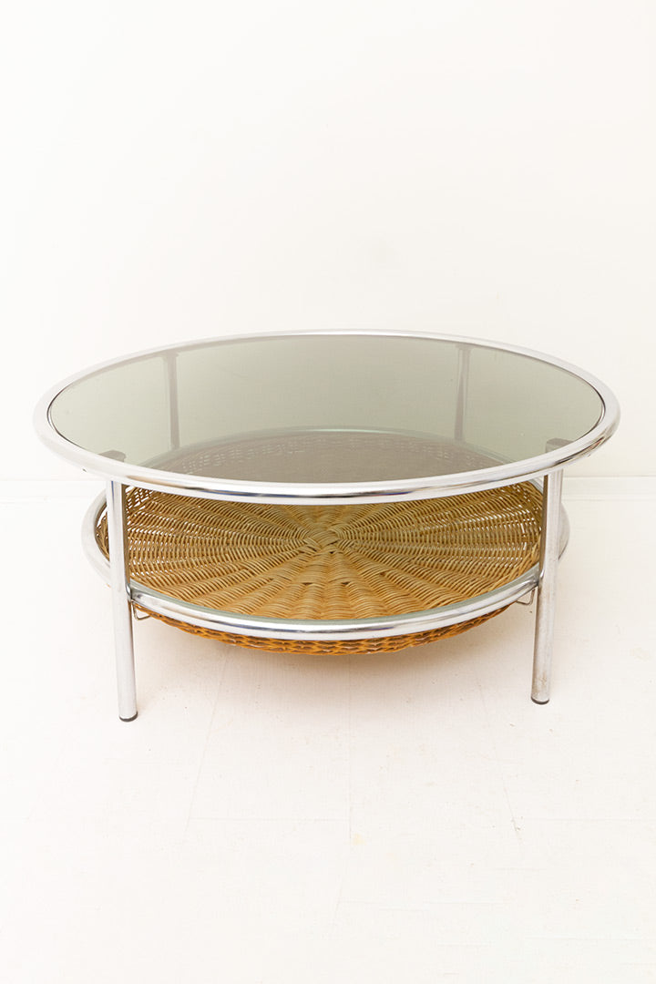 Vintage ronde salontafel met verchroomd frame, glazen blad en rotan krantengedeelte