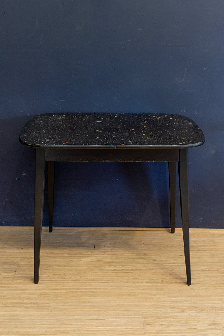Vintage zwarte eettafel met gekleurd confetti blad
